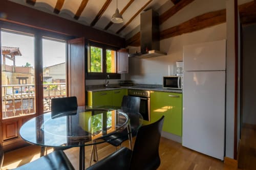 Bright kitchen-dining area in La Viña 2 apartment with lime green cabinets, stainless steel appliances, and balcony view