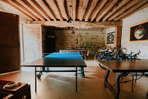 Recreation room at Casas Rurales La Viña with ping pong table, pool table, and bicycles under wooden beams