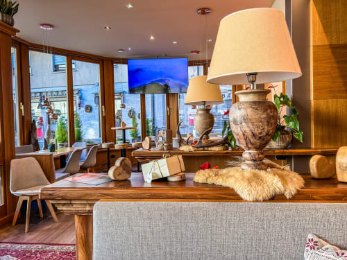 Banco reception del Ristorante Hotel Moderno a Serina con arredamento in legno, lampade color crema e vista montagna dalle finestre.