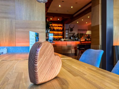 Decorazione in legno a forma di cuore sul tavolo della sala da pranzo dell'Hotel Moderno Restaurant a Serina, Italia