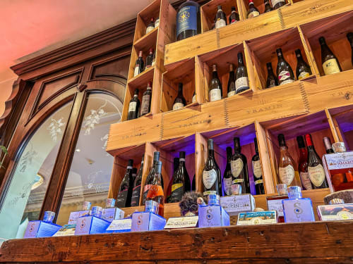 Esposizione della collezione di vini al Ristorante Hotel Moderno di Serina, con scaffalature in legno, bottiglie e raffinati dettagli lignei