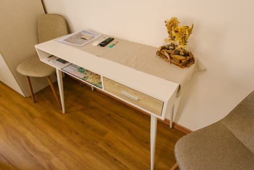 Scrivania moderna nell'appartamento di Verona con cornice bianca, cassetto in legno, sedia, fiori secchi decorativi e accessori da ufficio