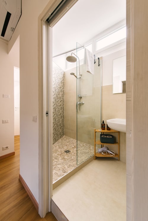 Bagno moderno con cabina doccia, lavabo su colonna e ripiani in legno nell'appartamento di Provincia di Verona a Verona, Italia