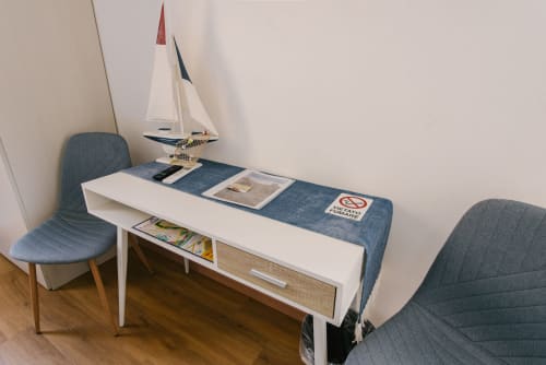 Moderna zona living in appartamento B&B a Verona con modello di barca a vela, sedie da pranzo e runner blu