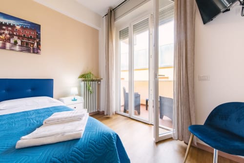 Camera moderna al 3 Guest House di Verona con testata blu, accesso al balcone e arredi contemporanei