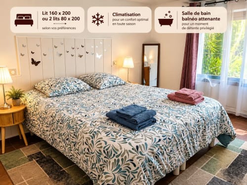 Chambre spacieuse à la Maison D'hôtes Coeur D'hérault avec literie motifs, vue sur jardin et équipements accueillants