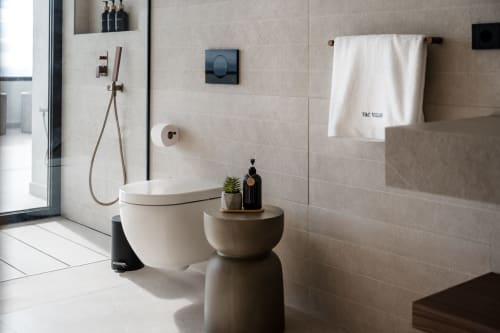 Baño moderno en villa de VC Luxury Village con inodoro blanco, ducha tipo lluvia con accesorios bronce y revestimiento de mármol