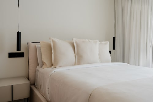 Lujosa cama con ropa de cama blanca y almohadas color crema en la villa Alisio de V&C en VC Luxury Village, Breña Baja