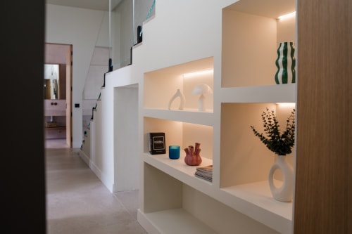 Pasillo elegante de villa moderna con estanterías integradas, jarrones decorativos e iluminación cálida en VC Luxury Village, Breña Baja