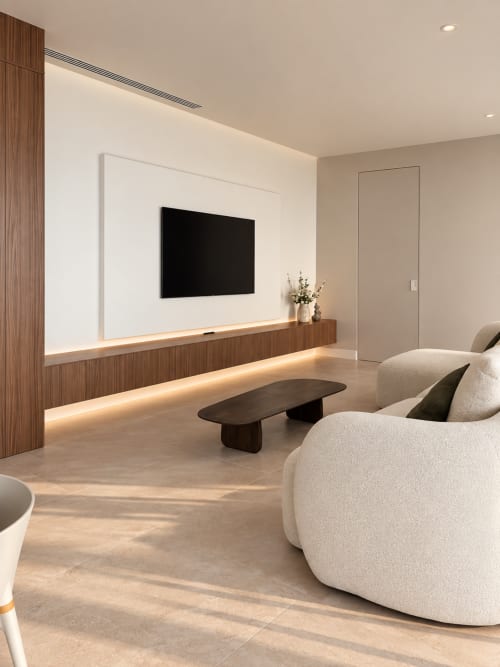 Elegante salón de villa moderna con sillones crema, mesa de café negra y TV mural en VC Luxury Village, Breña Baja