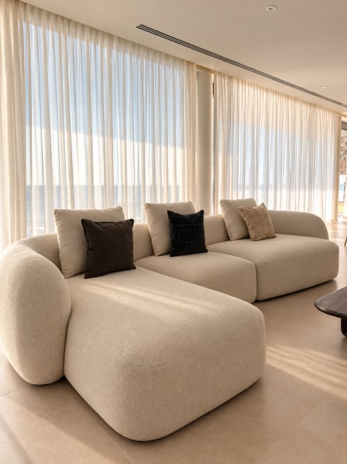 Sofá seccional curvo beige moderno con cojines negros en villa VC Alisio, Breña Baja