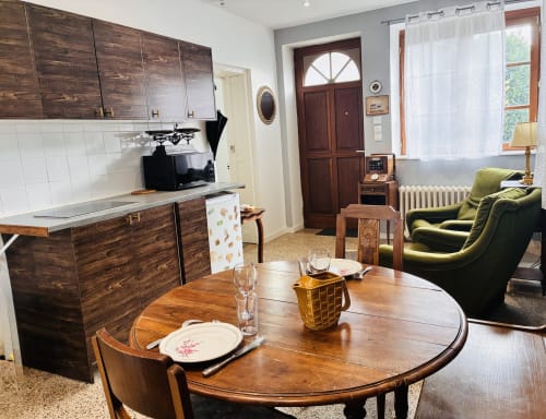 Coin repas et kitchenette de l'appartement Romance chez Sir Guillaume aux Studios Chez Mary, Gannat, avec table en bois, teinte verte