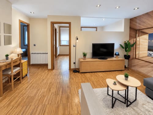 Moderno apartamento en Baiona con suelos de madera, televisor, cocina americana y vistas a la ciudad
