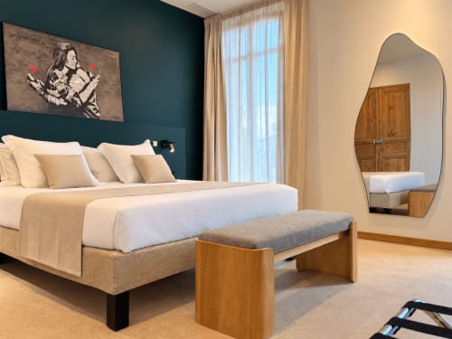 Chambre moderne au Palmier à Aigues-Mortes avec mur d'accent bleu-vert, lit king-size, banc en bois et miroir ovale