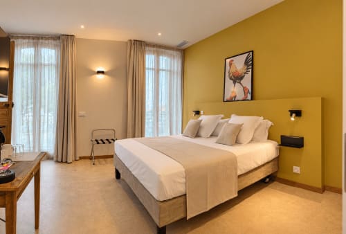 Chambre Standard moderne au Le Palmier Aigues-Mortes avec mur d'accent jaune, lit king-size, baies vitrées et design contemporain
