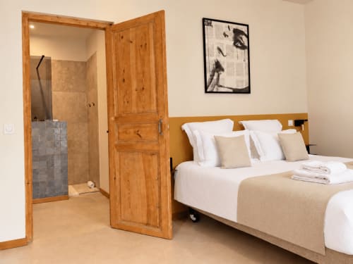 Chambre moderne au Palmier à Aigues-Mortes avec salle de bain attenante, lit queen-size et mobilier en bois