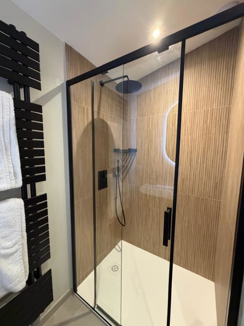 Douche moderne à cadre noir et carrelage imitation bois dans la Chambre Le Chai du Château Alto Cormeil, Saint-Émilion