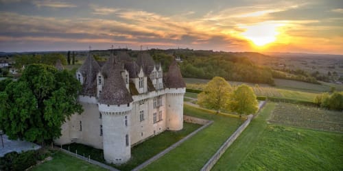 Château médiéval de l'Hôtel les Vieilles Pierres à Eymet, France, au coucher de soleil avec vue sur la campagne.