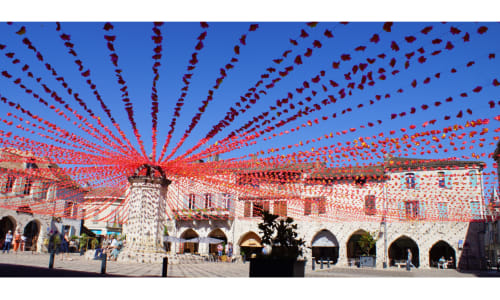 Place d'Eymet avec décorées de lanternes rouges et bâtiments historiques en pierre, Hôtel les Vieilles Pierres