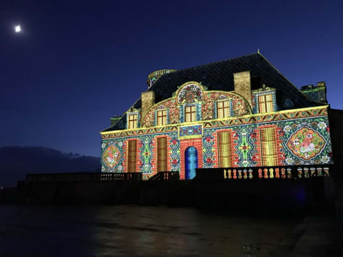 L'hôtel Les Vieilles Pierres à Eymet illuminé la nuit avec sa façade décorée aux couleurs chatoyantes