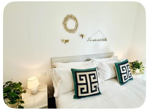 Camera moderna agli appartamenti Newhouse Bari con biancheria bianca, cuscini decorativi a motivo verde e pareti ispirati allo stile costiero
