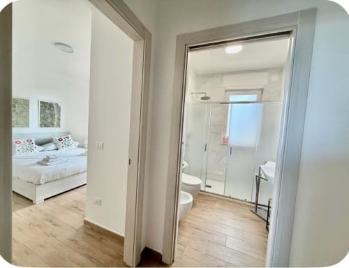 Corridoio moderno dell'appartamento Newhouse Bari con vista camera da letto e bagno ensuite con doccia walk-in