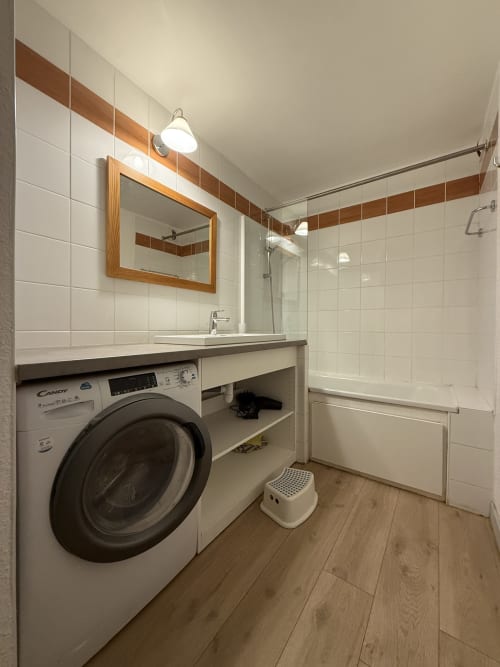 Salle de bain moderne avec machine à laver, lavabo et douche dans l'appartement La Plagne Ski Confort