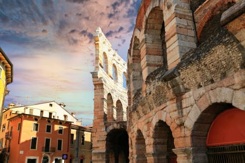 Rovine dell'anfiteatro romano antico di Verona con edifici in terracotta al tramonto