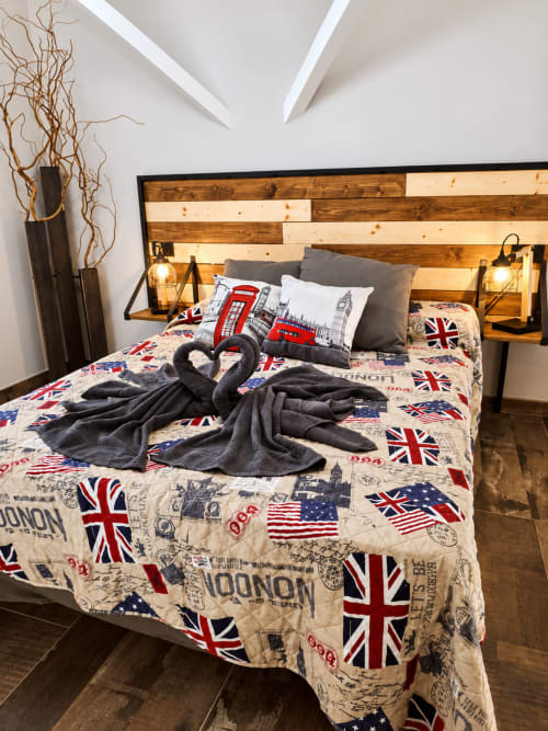 Camera da letto elegante al TuffonelBlu Ventimiglia con biancheria a tema britannico, testata in legno e cigni decorativi in asciugamani