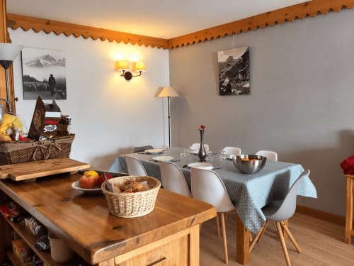 Espace de restauration chaleureux à La Plagne Ski Confort avec tables en bois, photographies de montagne et décor rustique de refuge alpin