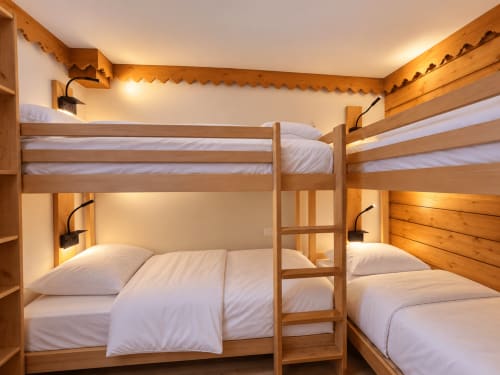 Chambre confortable avec lits superposés à La Plagne Ski Confort, structures en bois, literie blanche et ambiance chaleureuse à Aime 2000