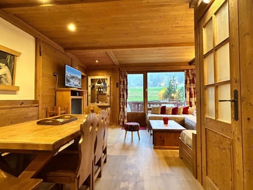 Intérieur en bois d'un appartement alpin à La Plagne avec salle à manger, vue montagne et coin cheminée