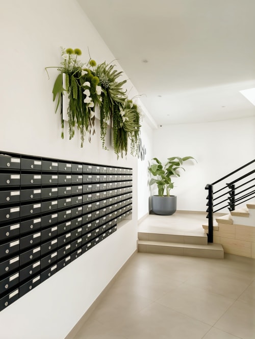 Modern apartment hallway with black mailboxes, hanging plants, and staircase at Manage Home Tenerife, Costa Adeje