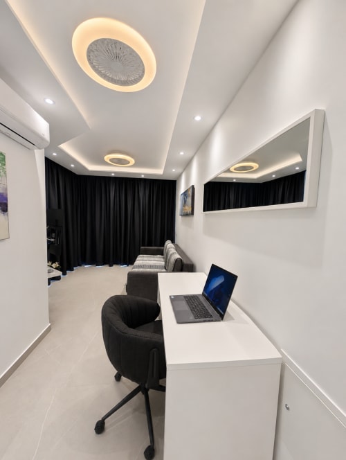 Modern apartment workspace at Manage Home Tenerife, Costa Adeje with laptop, desk chair, and contemporary ceiling lighting