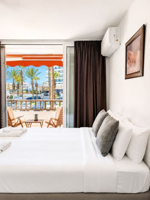 Modern bedroom with balcony overlooking palm trees and sea in Playa de las Américas, Tenerife