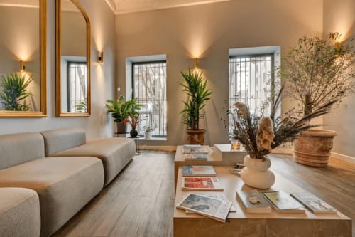 Hall contemporain du Boutique Hôtel Provencia à Marseille avec sièges gris incurvés, plantes et éclairage chaleureux