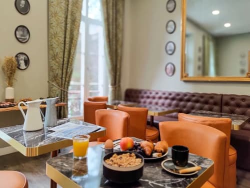 Lounge du Boutique Hôtel Provencia à Marseille avec fauteuils orange, tables en marbre et mobilier élégant