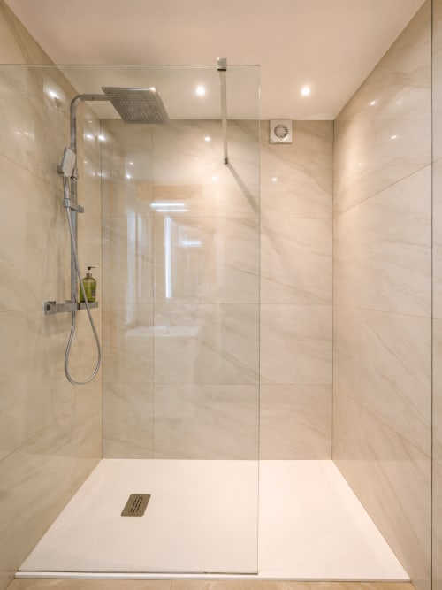 Modern shower enclosure with marble tiles at Manage Home Tenerife apartment in Playa de las Américas