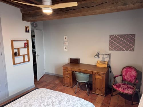 Chambre avec bureau en bois, chaise, lit et ventilateur de plafond au Gîte La Maison du Petit Louis, Changy Tourny
