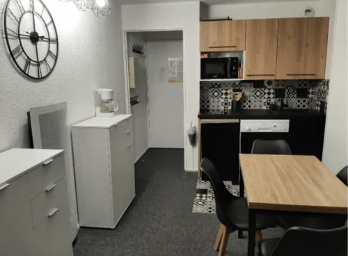 Cuisine et salle à manger modernes de l'appartement GNM 656, Vars. Armoires en bois, électroménagers noirs, dosseret à motifs, bois