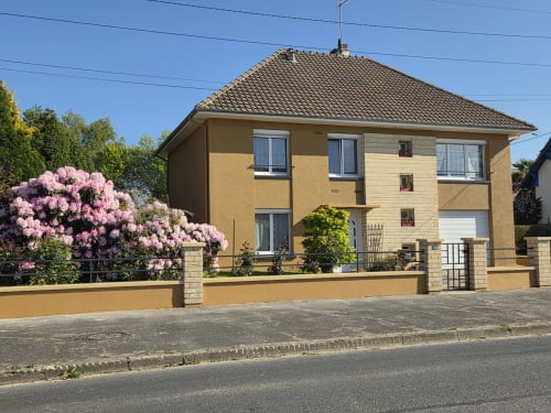 Cottage Au Gîte d'Isigny en Isigny-sur-Mer con flores rosas florecidas y vistas al jardín