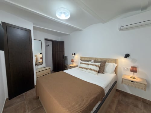 Dormitorio Alquería en Casa La Almedina, Casarabonela con cama king, muebles de madera y comodidades modernas