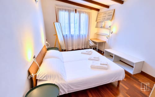 Camera da letto moderna e luminosa dell'appartamento Hometoday a Padova con letto matrimoniale, scrivania di lavoro e vista sul giardino