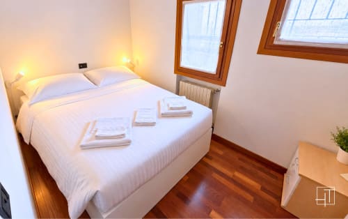 Camera moderna nell'appartamento Hometoday a Padova con letto bianco, pavimenti in legno e vista sul giardino