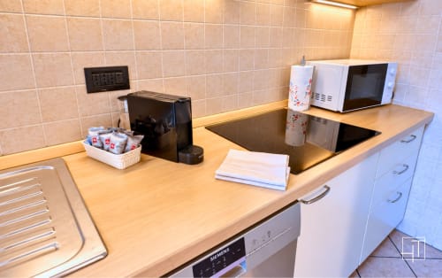 Angolo cottura moderno nell'appartamento Hometoday a Padova con caffettiera, microonde, piano cottura e essenziali da pranzo