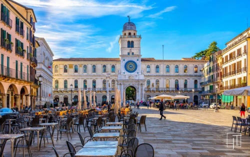 Piazza della Frutta a Padova con l'antico campanile orologio, servizi ai tavoli all'aperto e architettura rinascimentale