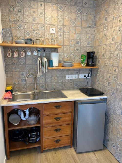 Pequena cozinha na casinha Curral em Casas do Sinhel com pia, frigobar, cafeteira e azulejos estampados na parede