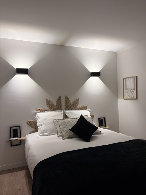 Chambre moderne à l'Hôtel les Vieilles Pierres à Eymet avec literie blanche, coussin noir et tête de lit tissée géométrique