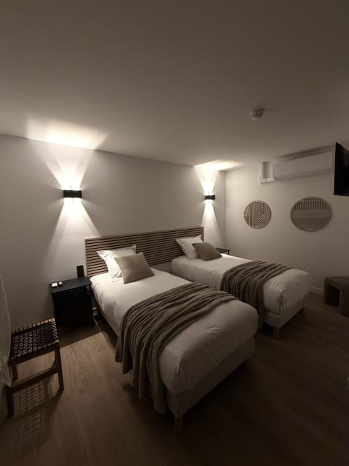 Chambre twin moderne à l'Hôtel les Vieilles Pierres à Eymet avec éclairage contemporain et tête de lit rayée