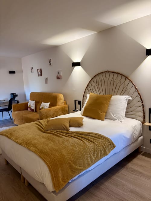 Chambre moderne à l'Hôtel les Vieilles Pierres à Eymet avec accents moutarde, tête de lit coquille et design contemporain